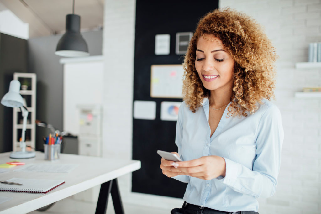 Woman using mobile phone in office