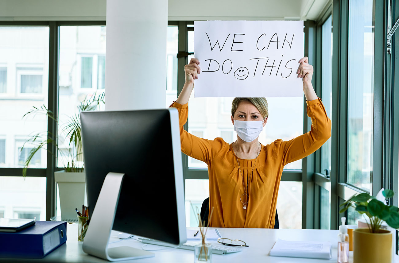 woman working holding up sign with encouraging message