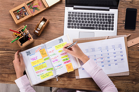 Woman writing in calendar at work